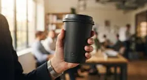 Hand holding a disposable plastic cup